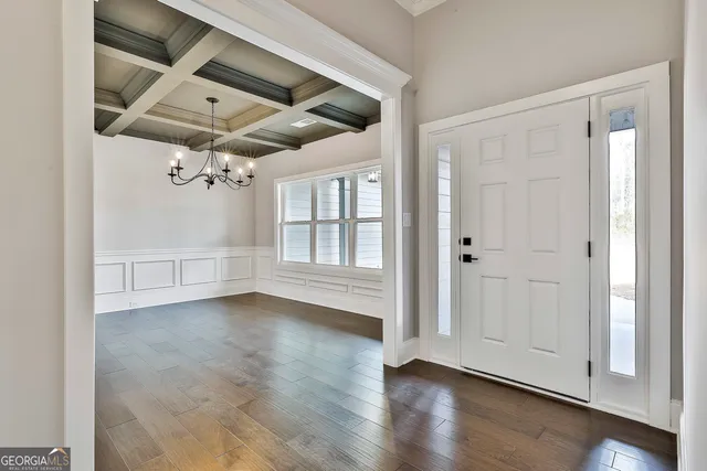 an empty room with wooden floor cabinet and windows