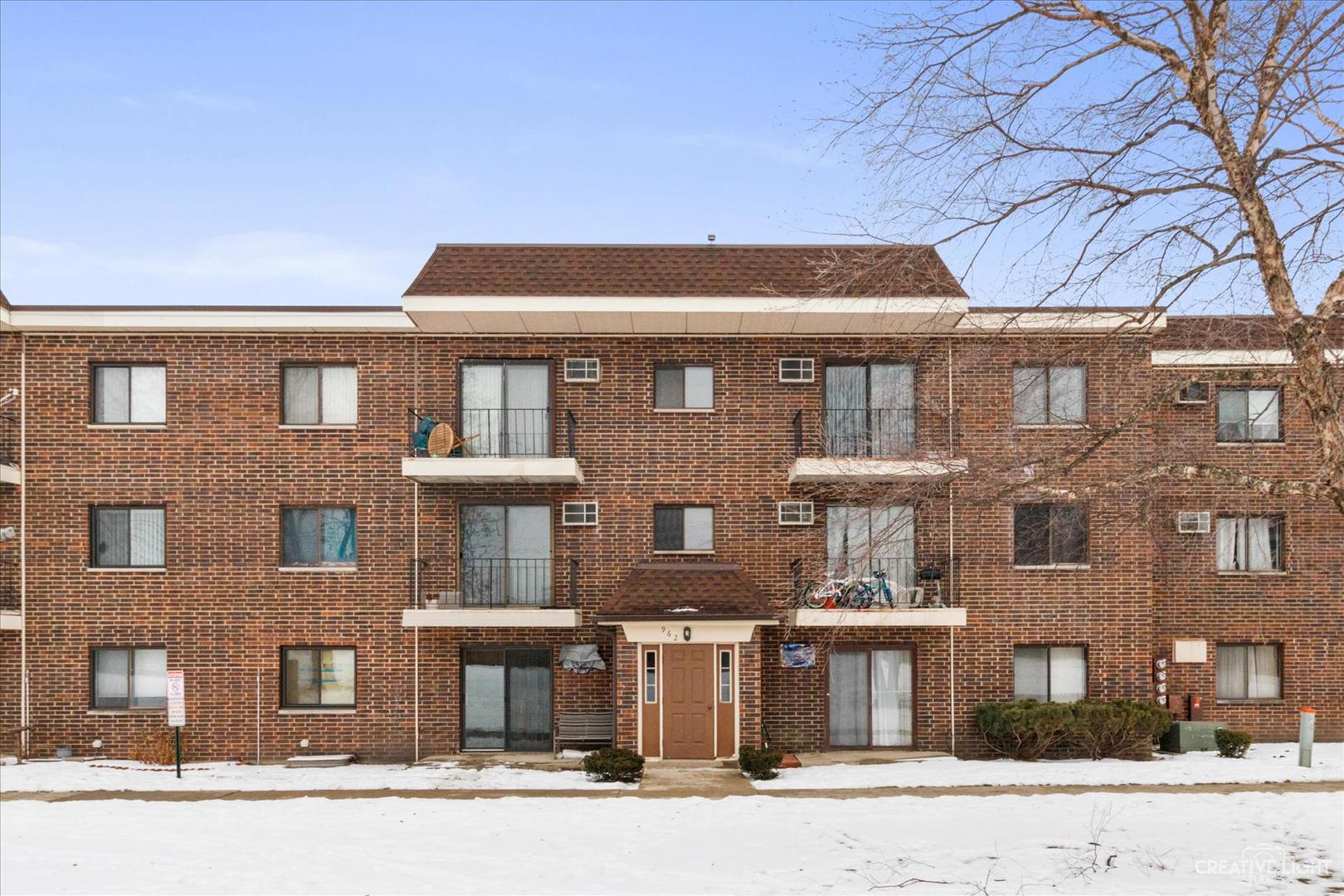 962 North Rohlwing Road, Unit 201B Addison, IL 60101 - Photo 1 of 18 a front view of a residential apartment building with a yard
