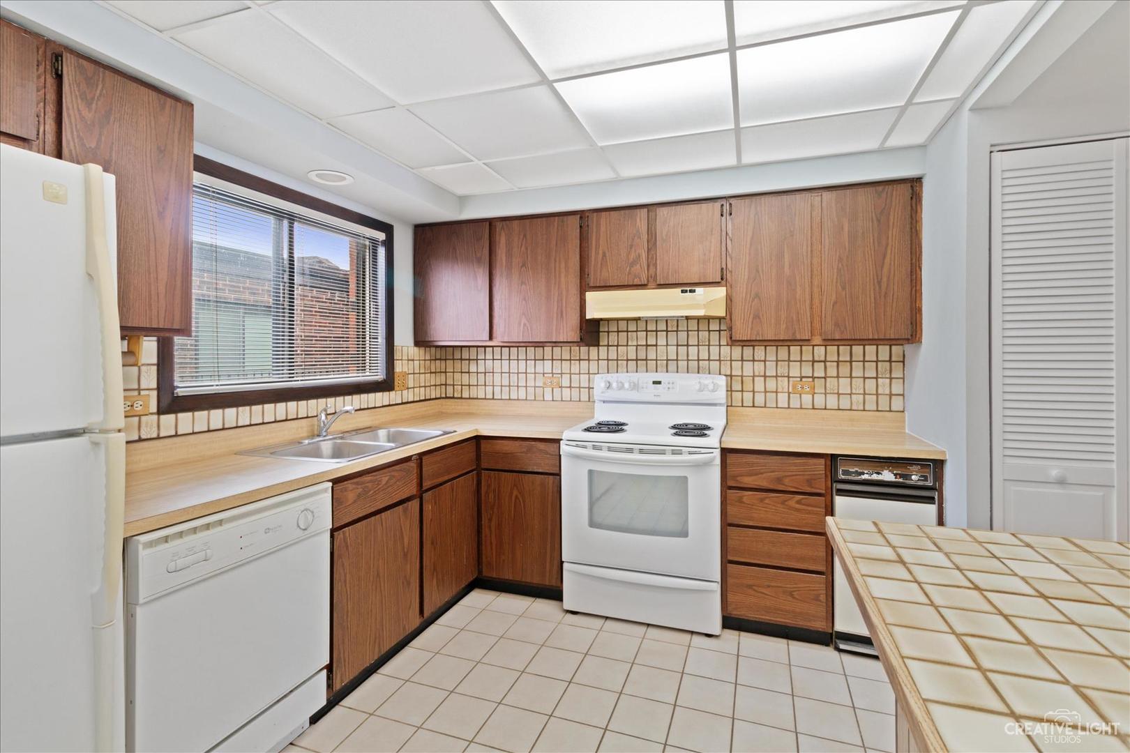 962 North Rohlwing Road, Unit 201B Addison, IL 60101 - Photo 11 of 18 a kitchen with a stove sink and cabinets