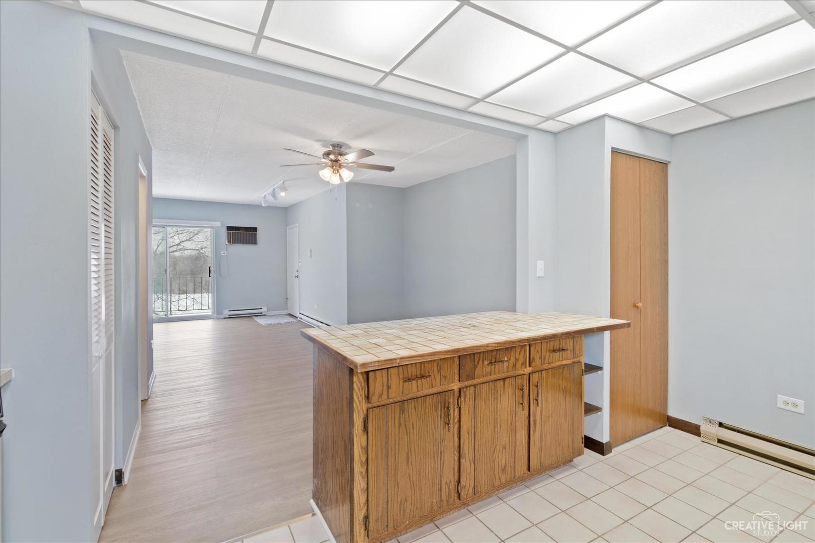 962 North Rohlwing Road, Unit 201B Addison, IL 60101 - Photo 12 of 18 a view of a kitchen with kitchen island a sink wooden floor and chandelier