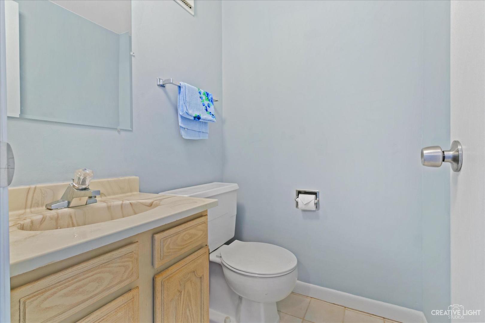 962 North Rohlwing Road, Unit 201B Addison, IL 60101 - Photo 13 of 18 a bathroom with a sink mirror vanity and toilet