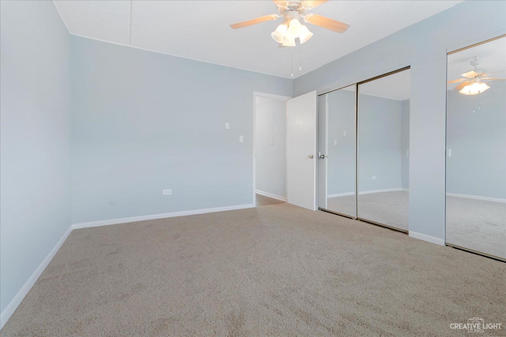 962 North Rohlwing Road, Unit 201B Addison, IL 60101 - Photo 16 of 18 a view of an empty room with a chandelier fan