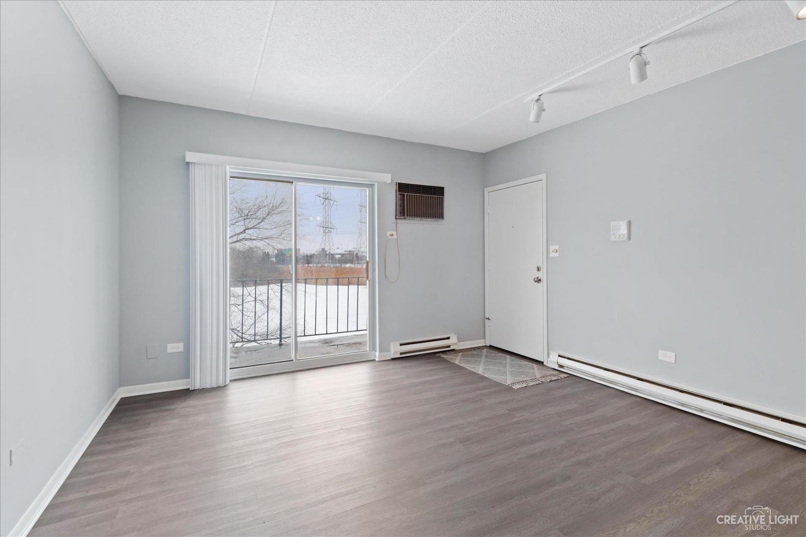 962 North Rohlwing Road, Unit 201B Addison, IL 60101 - Photo 6 of 18 an empty room with wooden floor and windows