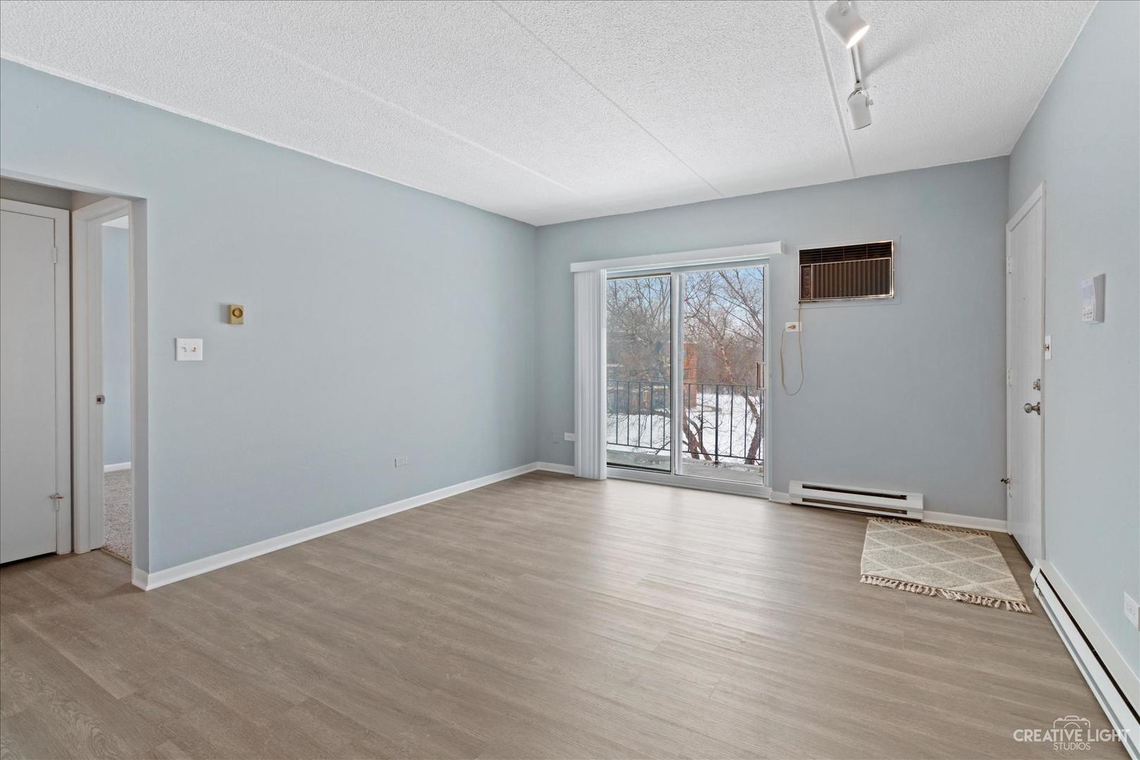 962 North Rohlwing Road, Unit 201B Addison, IL 60101 - Photo 9 of 18 a view of an empty room with wooden floor and a window