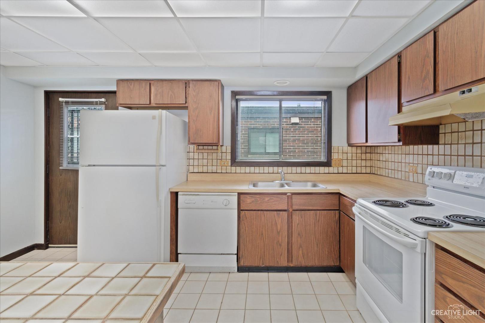 962 North Rohlwing Road, Unit 201B Addison, IL 60101 - Photo 10 of 18 a kitchen with stainless steel appliances a refrigerator sink and stove