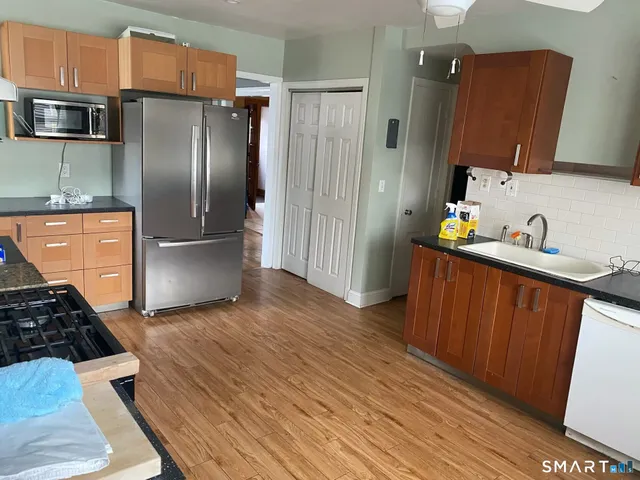 a kitchen with wooden floors and stainless steel appliances