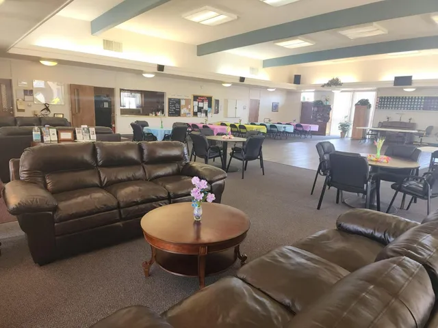 a living room with furniture kitchen view and a large window