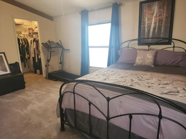 a bedroom with a bed and a window