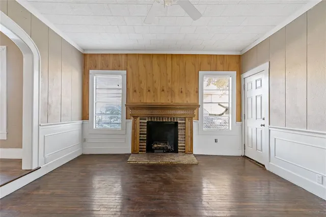 a view of a livingroom with wooden floor and a fireplace