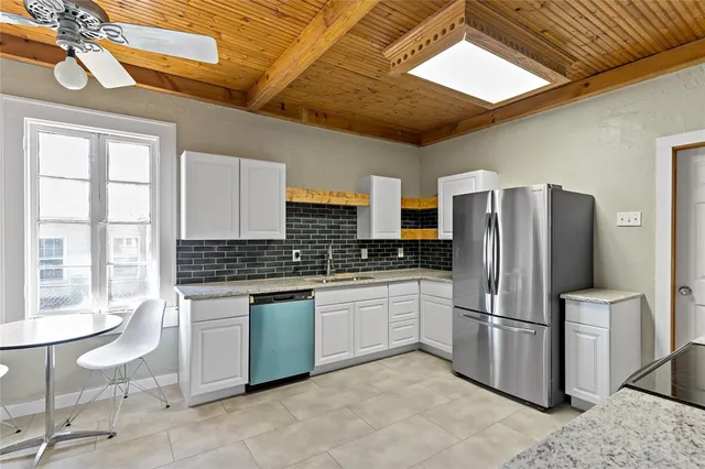 a kitchen with stainless steel appliances granite countertop a refrigerator a stove a sink and dishwasher