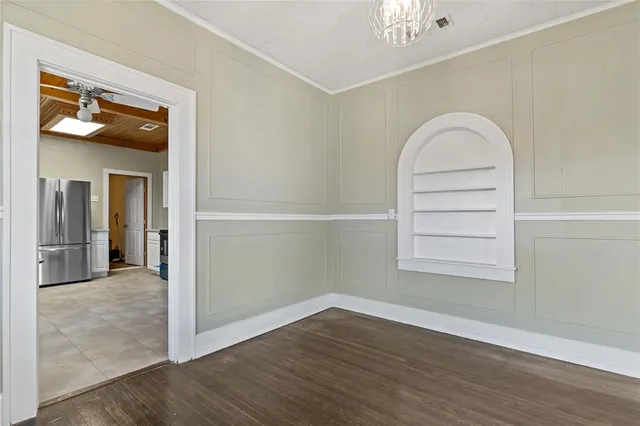 an empty room with wooden floor and window