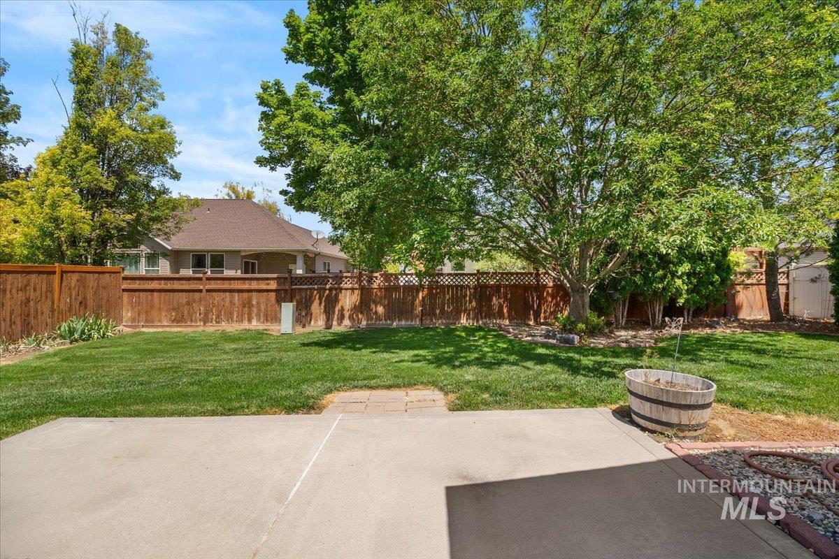 2032 Talus Loop Twin Falls, ID 83301 - Photo 40 of 43 Expansive backyard featuring a concrete patio, a manicured lawn, and mature trees
