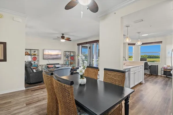 a kitchen with stainless steel appliances kitchen island granite countertop a stove a sink a refrigerator and white cabinets with wooden floor