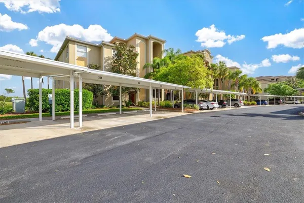a kitchen with stainless steel appliances kitchen island granite countertop a refrigerator a oven and a sink with large countertops