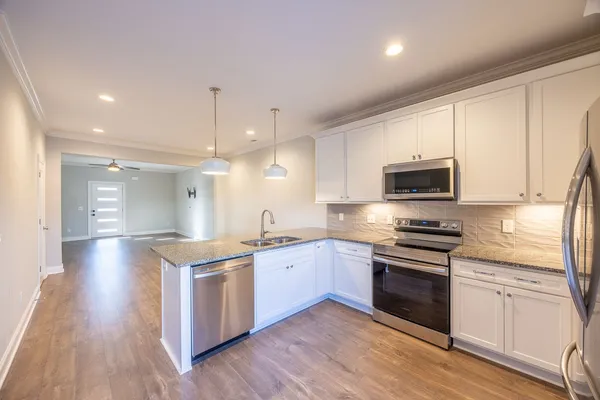 a kitchen with stainless steel appliances granite countertop a sink and stove top oven