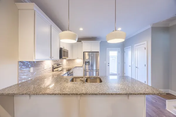 a kitchen with kitchen island granite countertop a sink a counter top space and cabinets