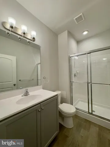 a bathroom with a sink a toilet a mirror and shower
