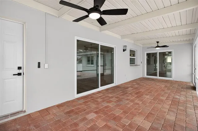 a view of empty room with wooden floor and ceiling fan