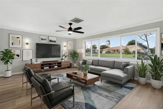 a living room with furniture a flat screen tv and a potted plant