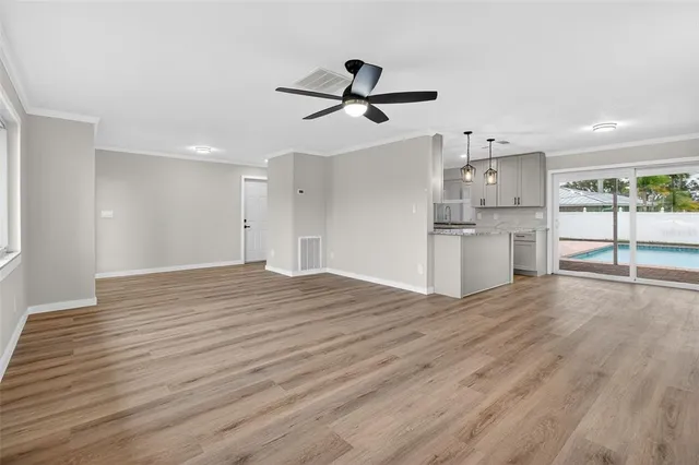 a view of empty room with wooden floor and window