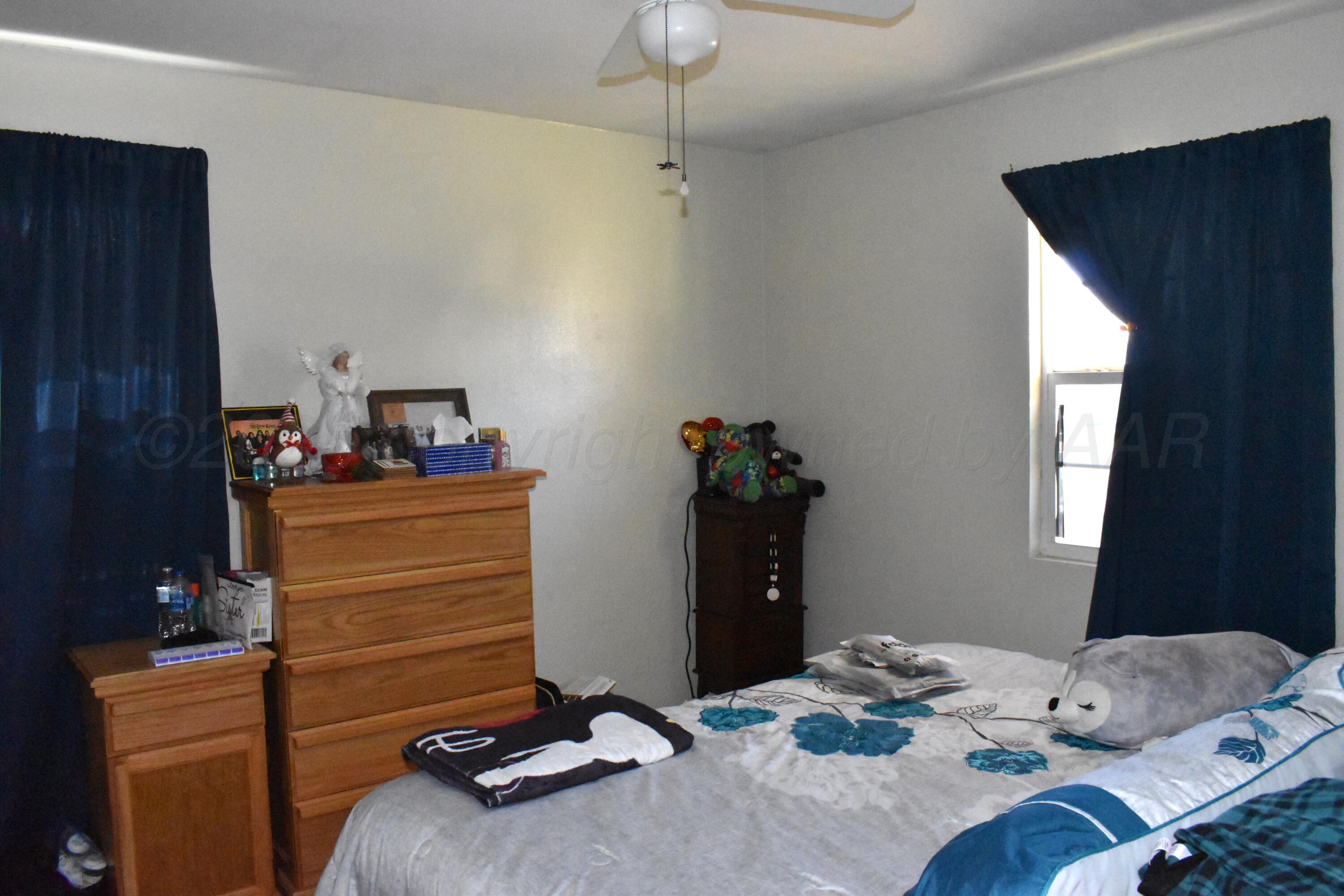 1919 Cherry Street Amarillo, TX 79106 - Photo 15 of 19 a bedroom with a bed and a chandelier