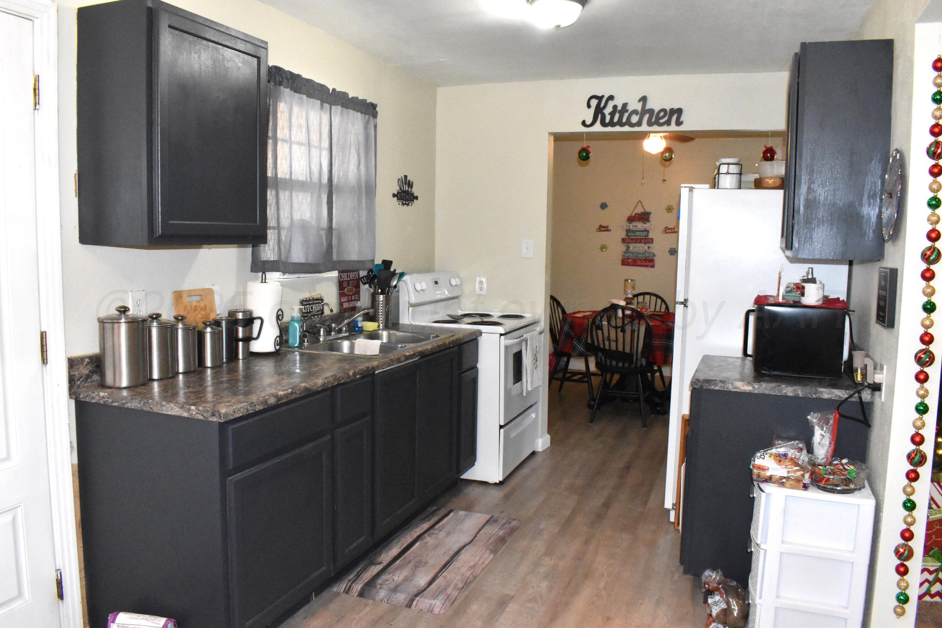 1919 Cherry Street Amarillo, TX 79106 - Photo 6 of 19 a kitchen with stainless steel appliances granite countertop a sink dishwasher stove and refrigerator with wooden floor