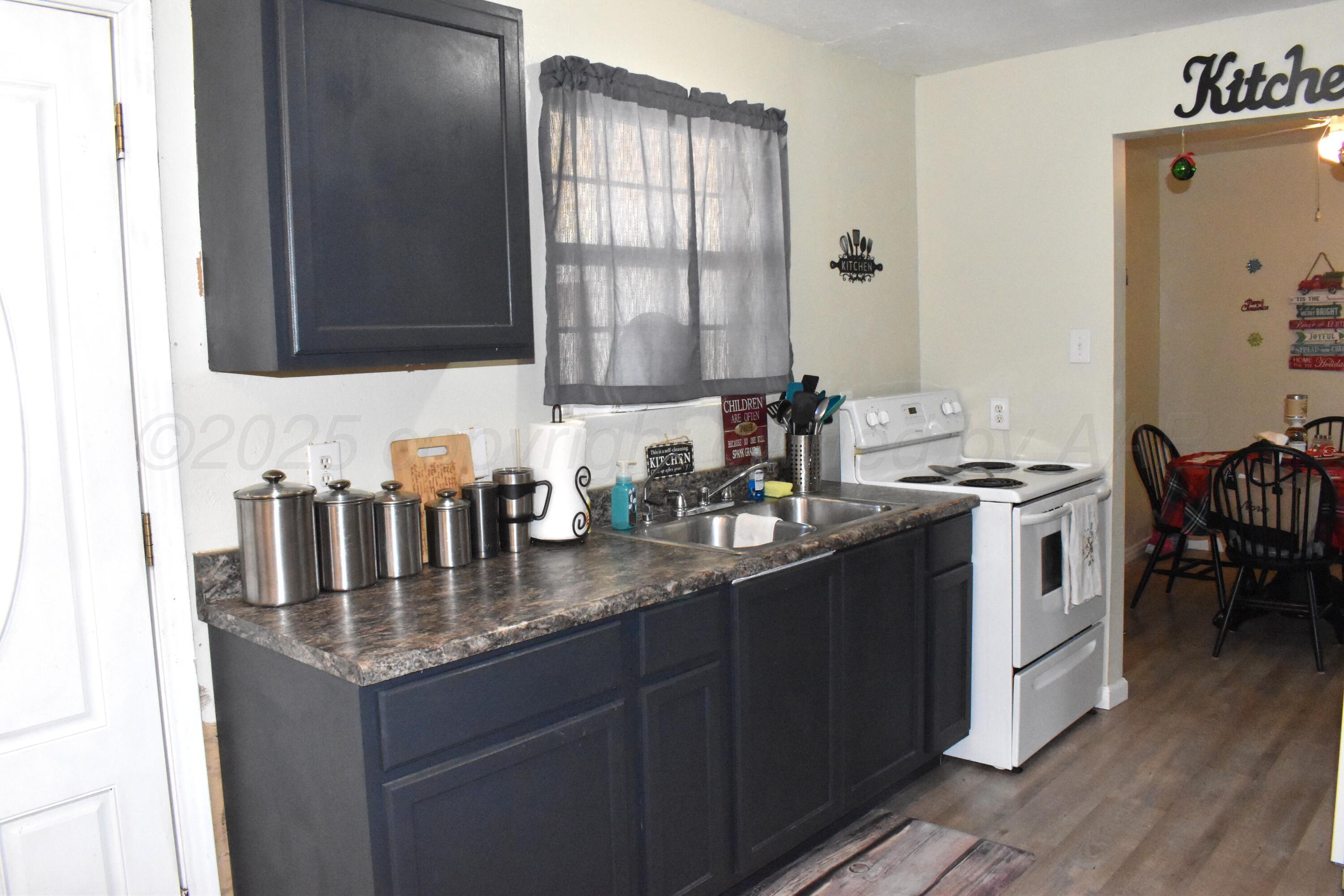 1919 Cherry Street Amarillo, TX 79106 - Photo 7 of 19 a kitchen with granite countertop a sink stove and cabinets