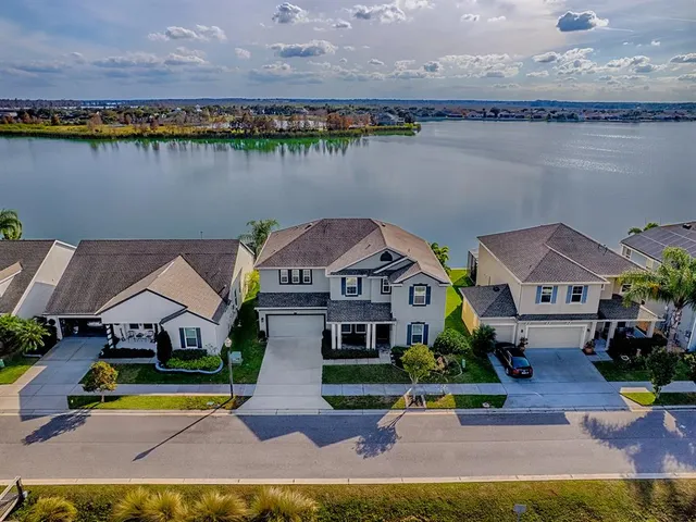 an aerial view of a house with a yard and a lake view