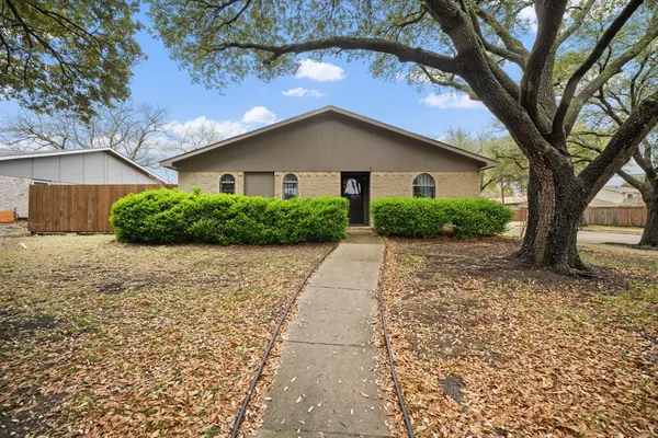 a view of a house with a yard and large tree