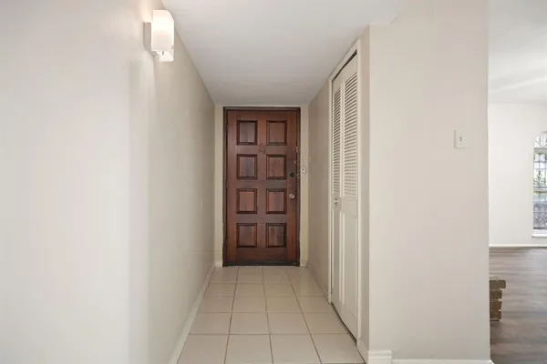 an empty room with wooden floor chandelier fan and windows
