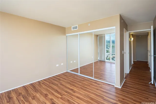 a view of empty room with wooden floor