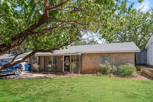 a view of a house with a yard and tree s