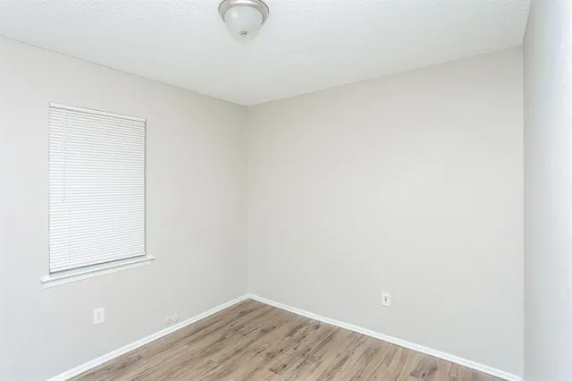 a view of a small space with wooden floor and a window
