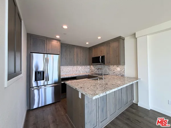 a kitchen with stainless steel appliances granite countertop a refrigerator and a sink