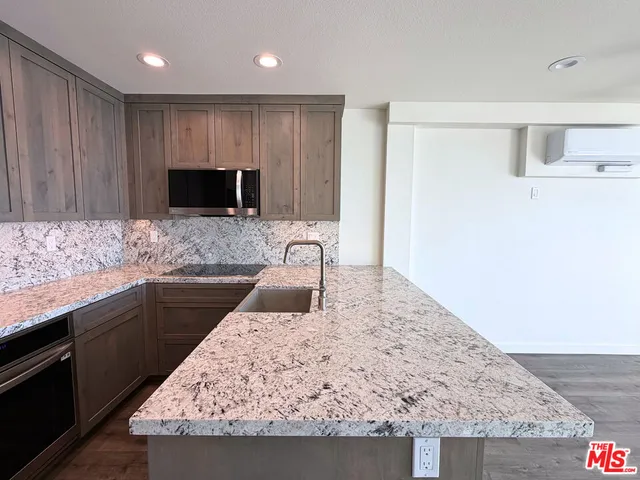 a kitchen with stainless steel appliances granite countertop a sink and a microwave