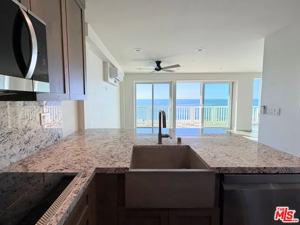 a kitchen with a sink a counter space and stainless steel appliances