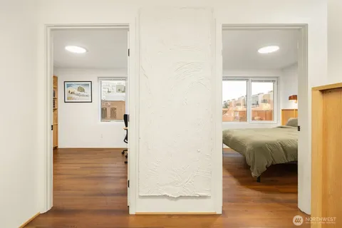 a view of a bedroom with wooden floor and a bathroom