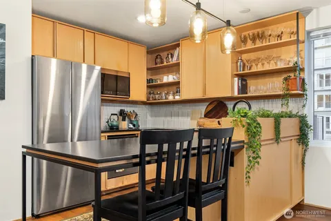 a kitchen with stainless steel appliances granite countertop a refrigerator a stove and a sink with granite countertops