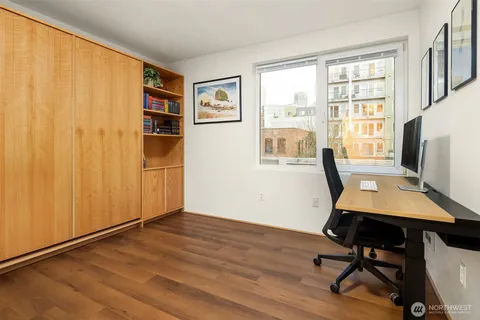 a view of a workspace with furniture and a window