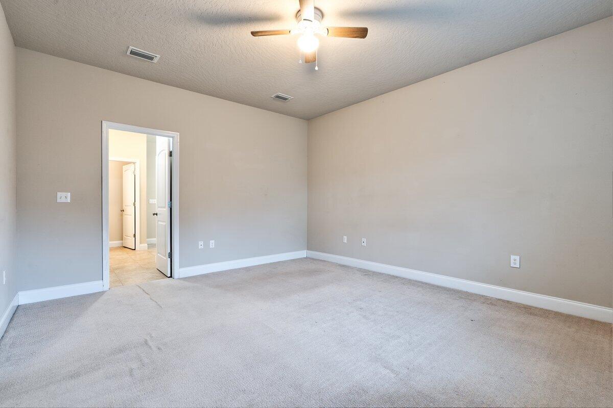 4614 Hermosa Road Crestview, FL 32539 - Photo 12 of 23 en empty room with ceiling fan and window