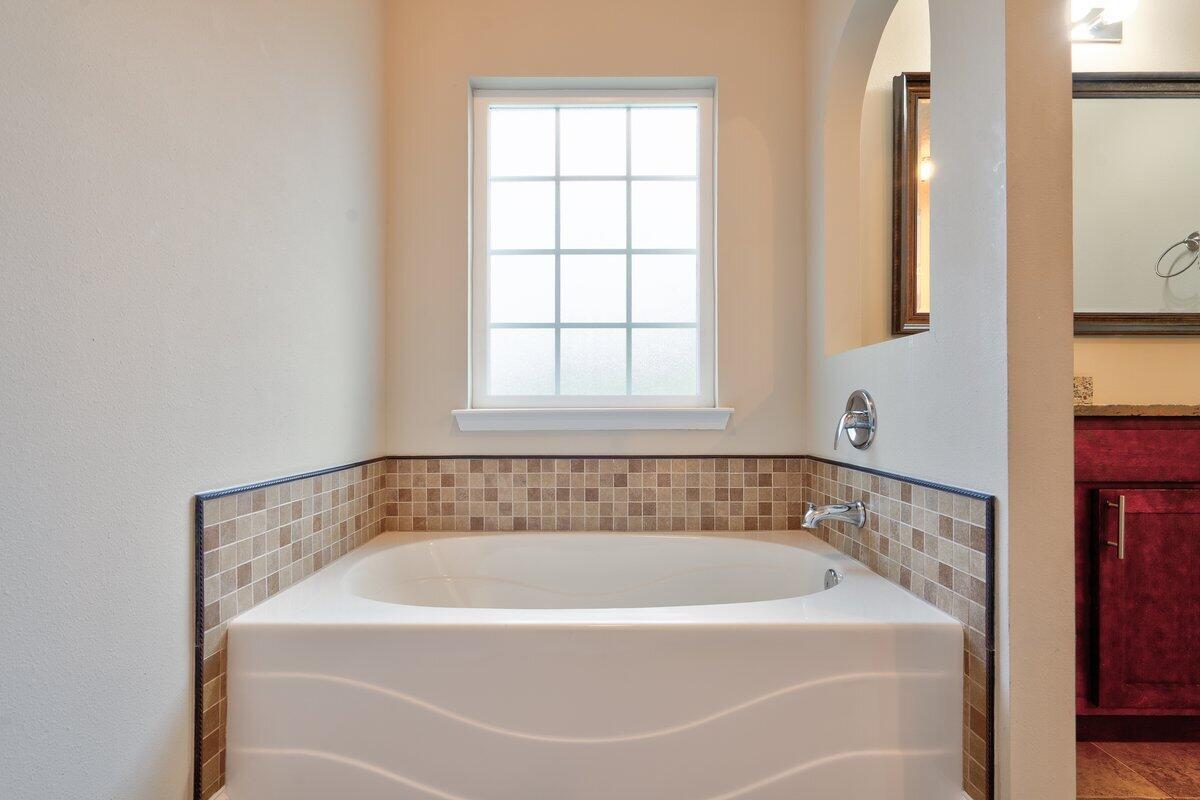 4614 Hermosa Road Crestview, FL 32539 - Photo 16 of 23 a white bath tub sitting in a bathroom next to a window