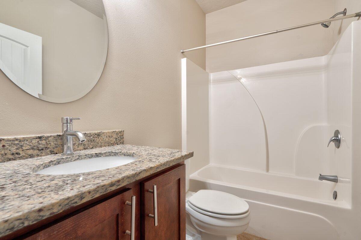 4614 Hermosa Road Crestview, FL 32539 - Photo 18 of 23 a bathroom with a granite countertop sink toilet and shower