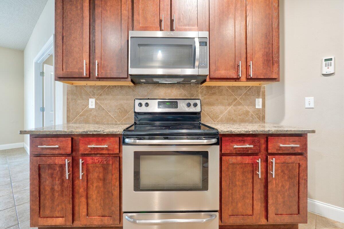 4614 Hermosa Road Crestview, FL 32539 - Photo 7 of 23 a kitchen with granite countertop wood cabinets stainless steel appliances and a sink
