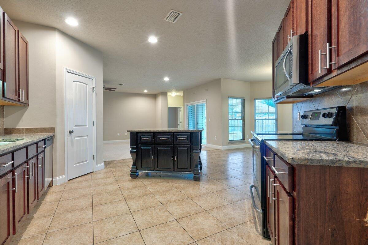 4614 Hermosa Road Crestview, FL 32539 - Photo 8 of 23 a kitchen with stainless steel appliances granite countertop a stove a sink and a refrigerator