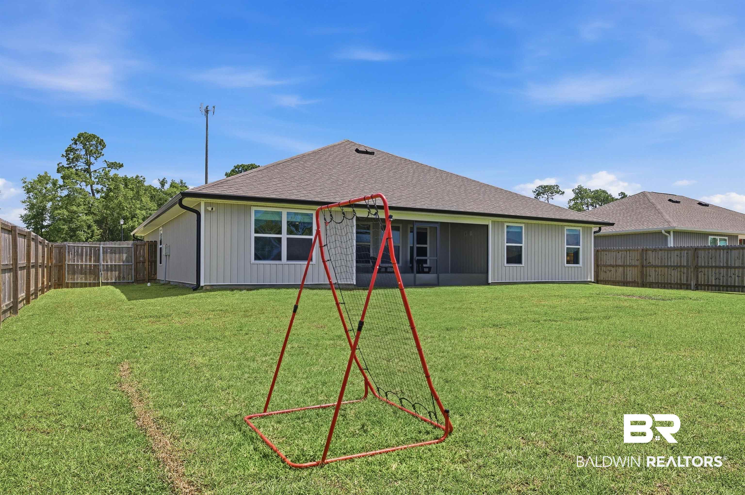 3213 Camino Real Loop Lillian, AL 36549 - Photo 8 of 61 Spacious rear yard with a perimeter wood fence, manicured lawn, and a covered screened patio