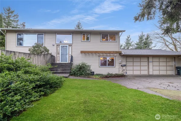 a front view of a house with a garden and yard