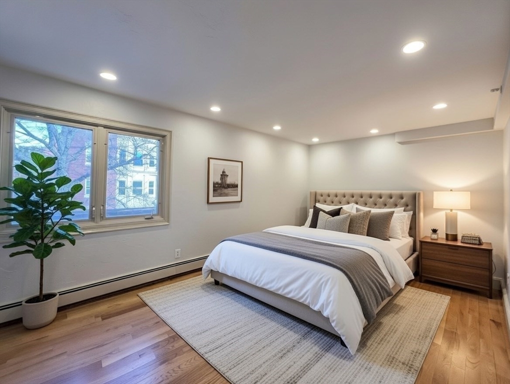 1002 Beacon Street Brookline, MA 02446 - Photo 13 of 17 a spacious bedroom with a large bed and a potted plant