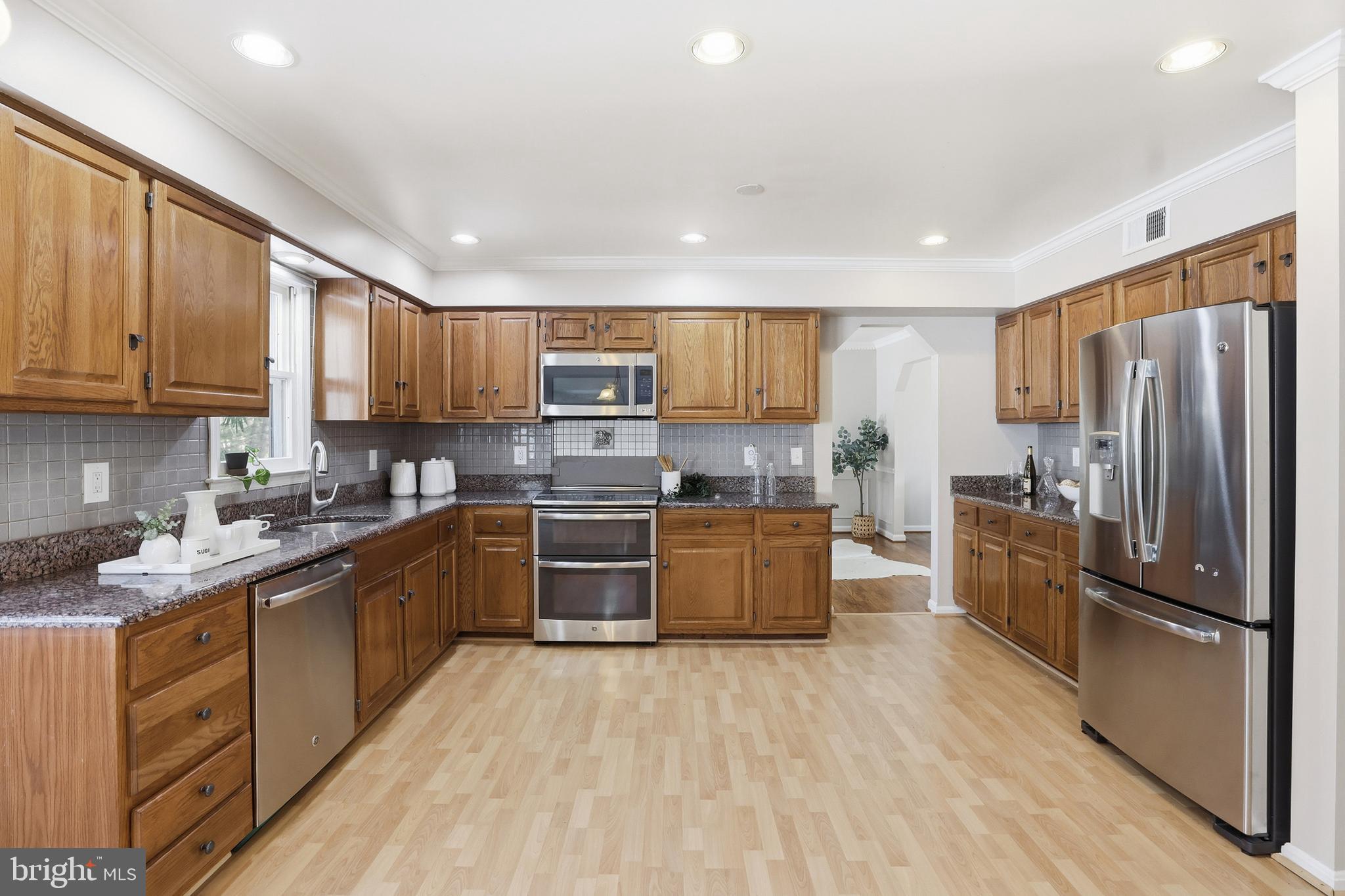 14740 Locustwood Lane Silver Spring, MD 20905 - Photo 11 of 46 a kitchen with stainless steel appliances granite countertop a refrigerator stove top oven and sink