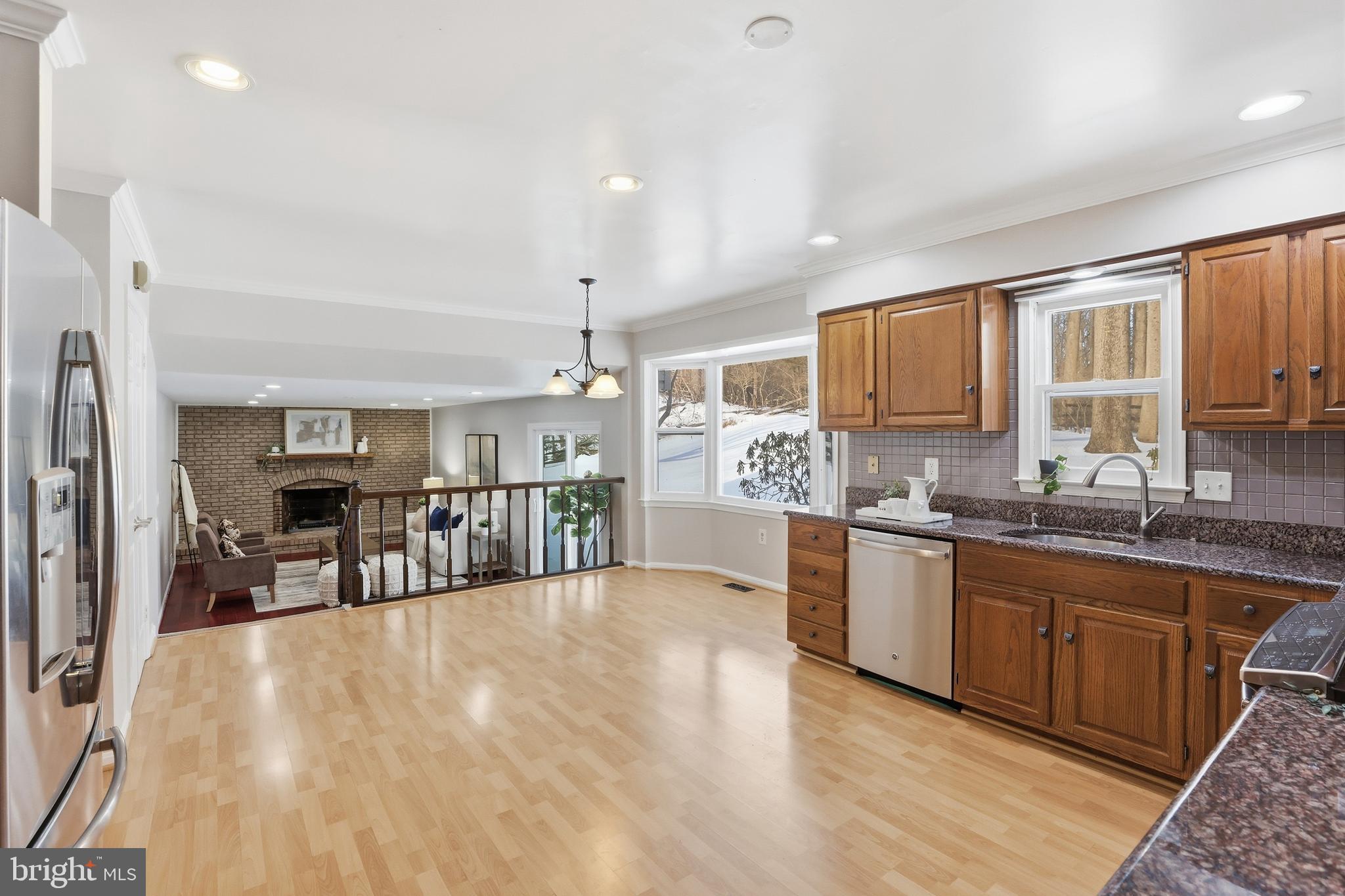 14740 Locustwood Lane Silver Spring, MD 20905 - Photo 12 of 46 a kitchen with stainless steel appliances kitchen island granite countertop a refrigerator a stove top oven a sink dishwasher and white cabinets with wooden floor