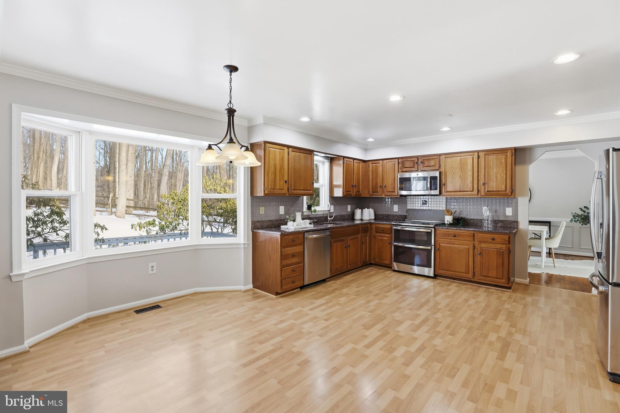 14740 Locustwood Lane Silver Spring, MD 20905 - Photo 13 of 46 a kitchen with stainless steel appliances granite countertop a stove top oven a refrigerator a sink and living room view